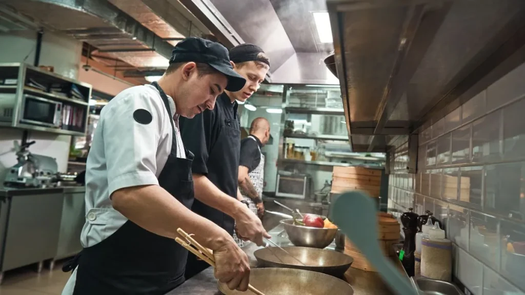 Ayudante de cocina preparando platos en restaurante de Nueva York