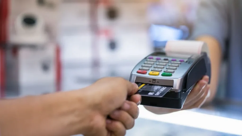 Mano escaneando una tarjeta de recompensas en la caja registradora